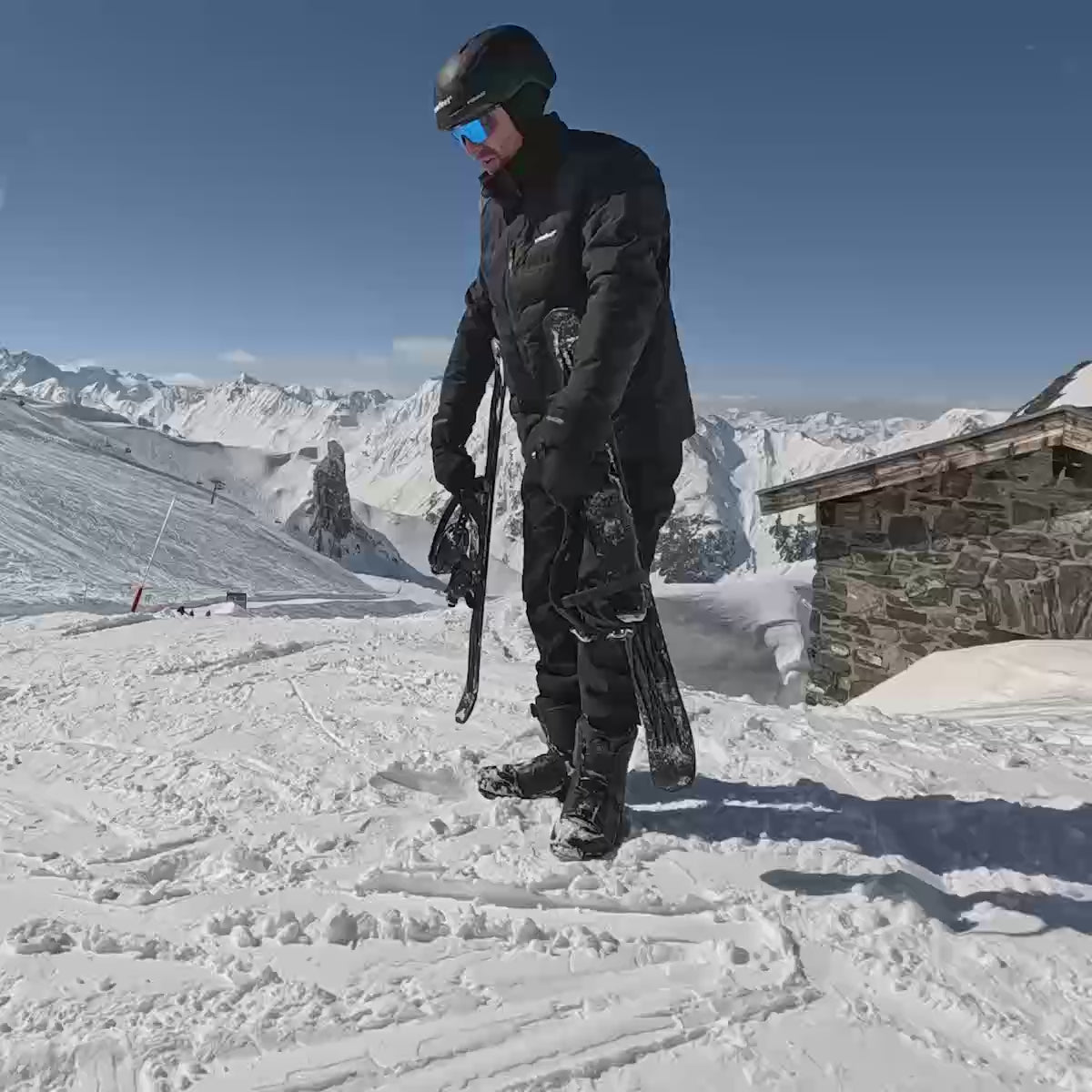 Man using Snowfeet Skiblades 100, putting them on and skiing down the slope