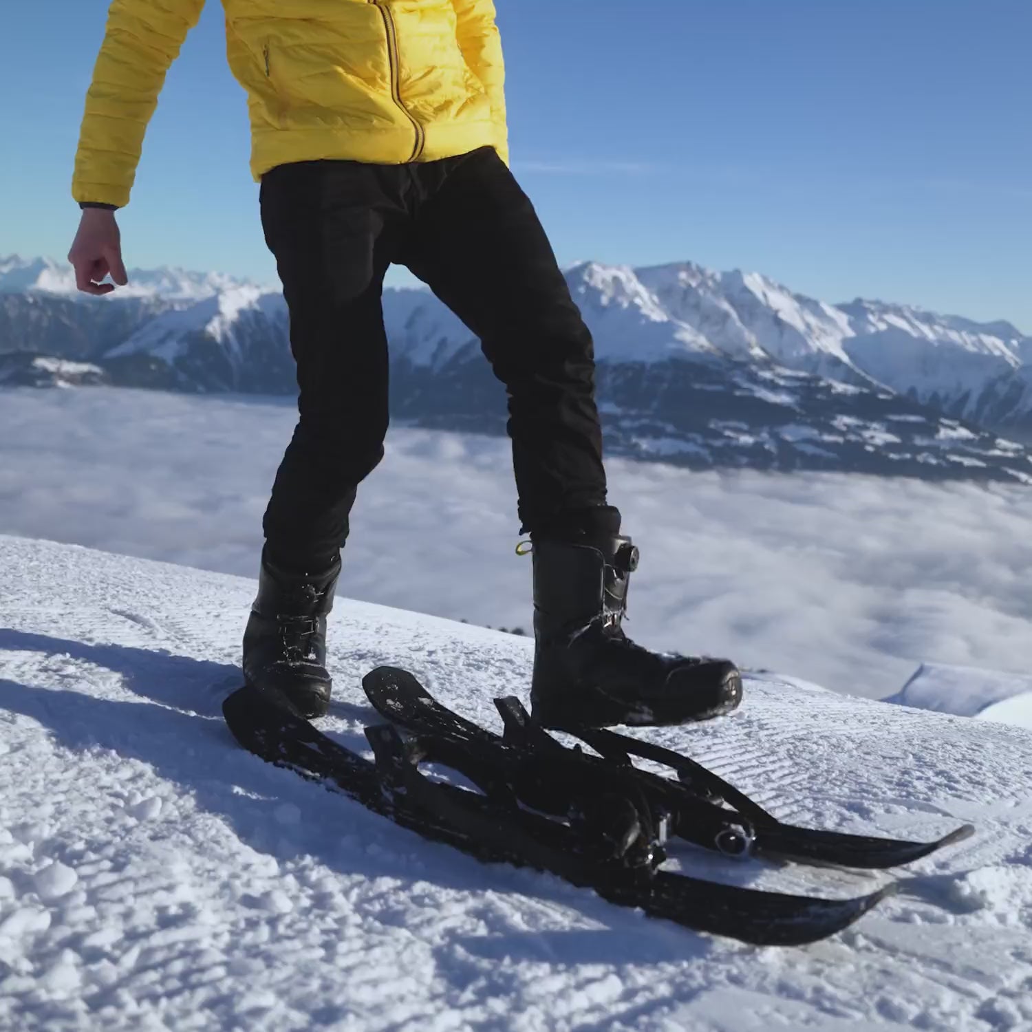 Man using Snowfeet Skiblades 100, putting them on and skiing down the slope